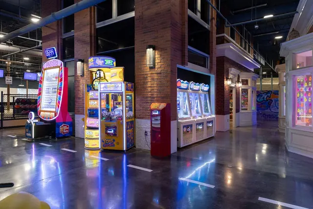 Arcade games along a brick storefront street inside The Alley