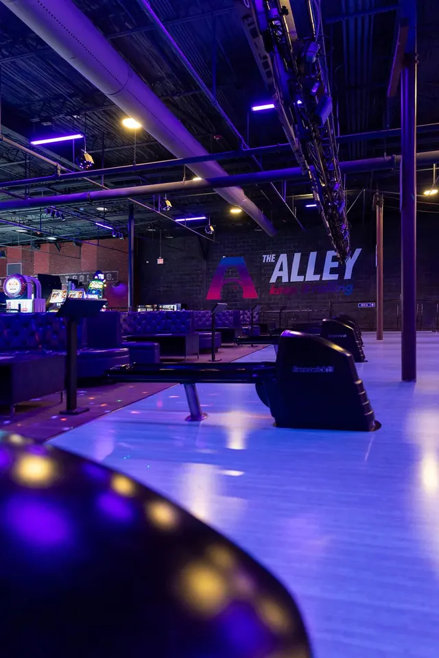 The Alley sign glowing blue over the lanes