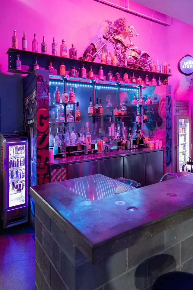 Bar lit pink and purple inside The Alley