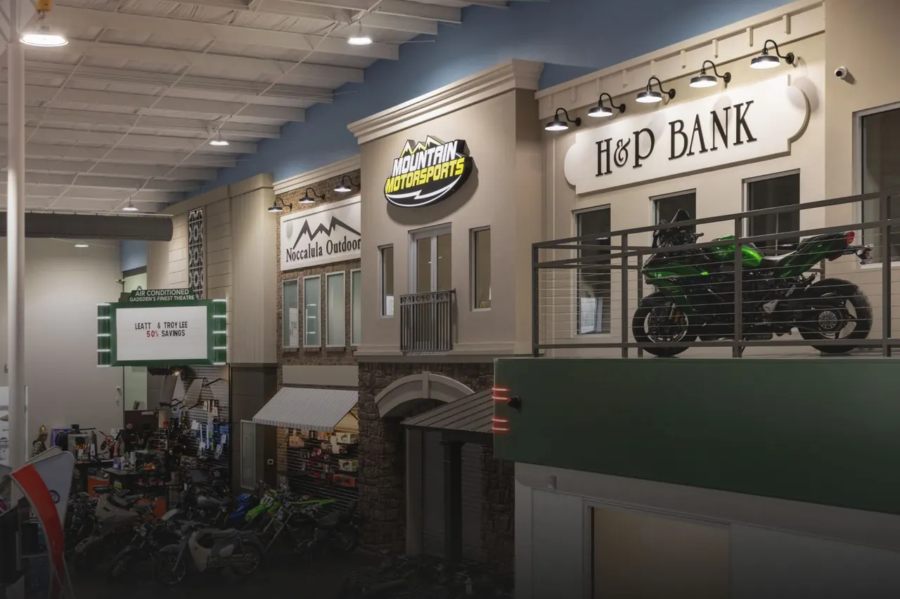Inside the Mountain Motorsports showroom in Gadsden: storefront facades and a motorcycle on the balcony