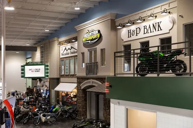 Storefront facades and a motorcycle on the balcony inside Mountain Motorsports