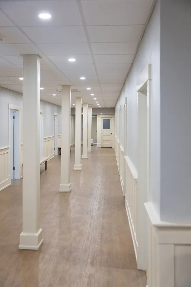 Bright hallway with white columns and wood floors