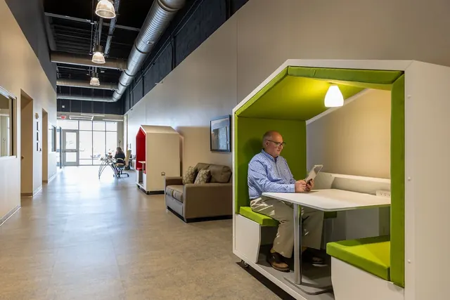 Open office at The Venue with a lime-green booth and exposed ductwork