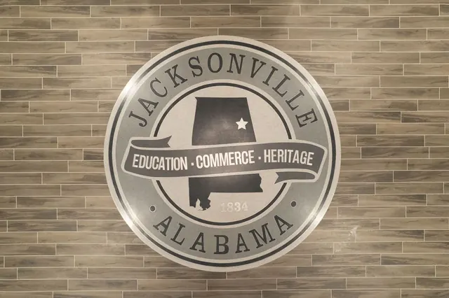 Jacksonville, Alabama seal on a brick wall: education, commerce, heritage